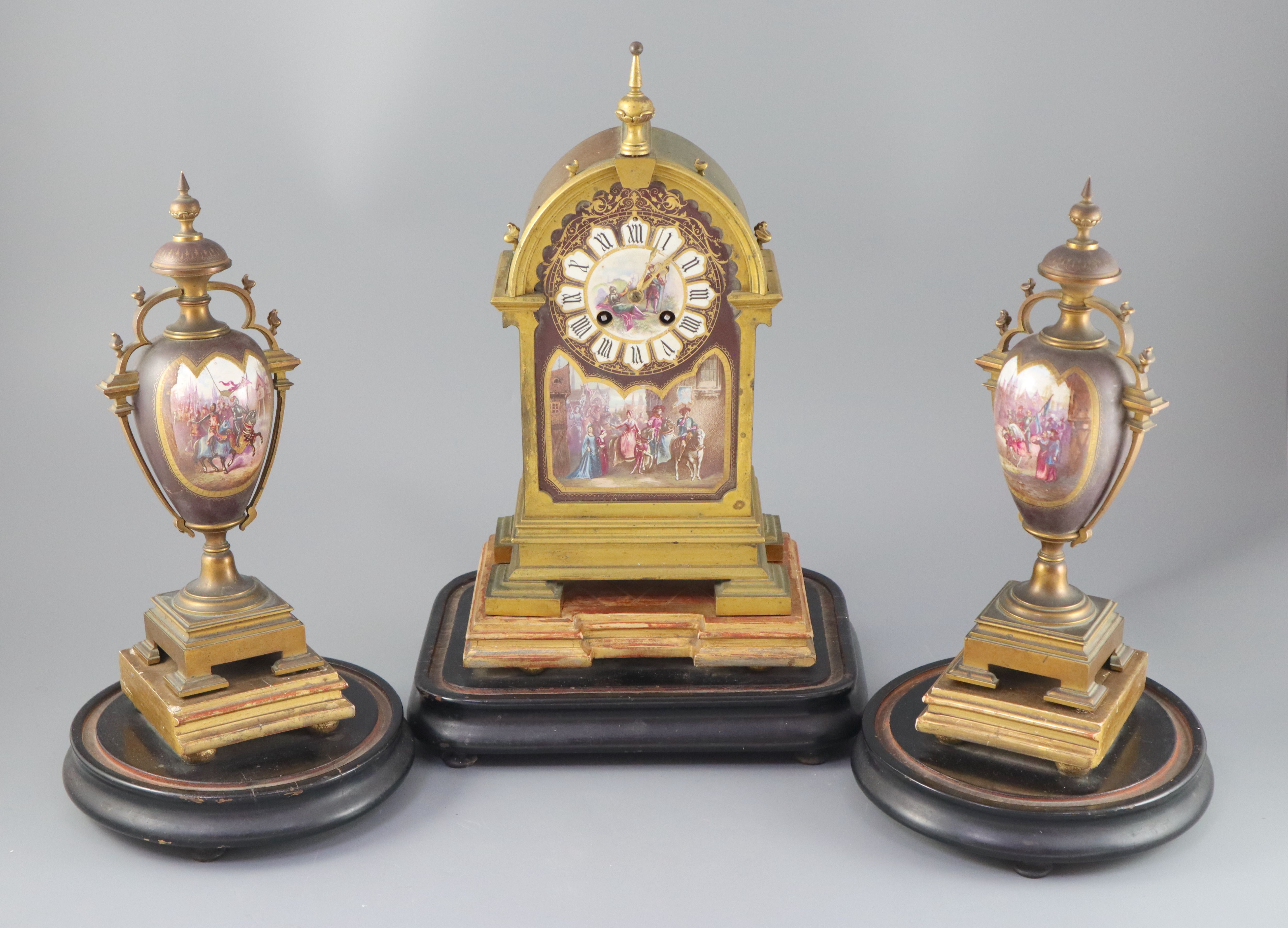 A 19th century French ormolu and enamelled porcelain clock garniture, clock height 13.75in. urns 11.5in. overall on both plinths 17in.